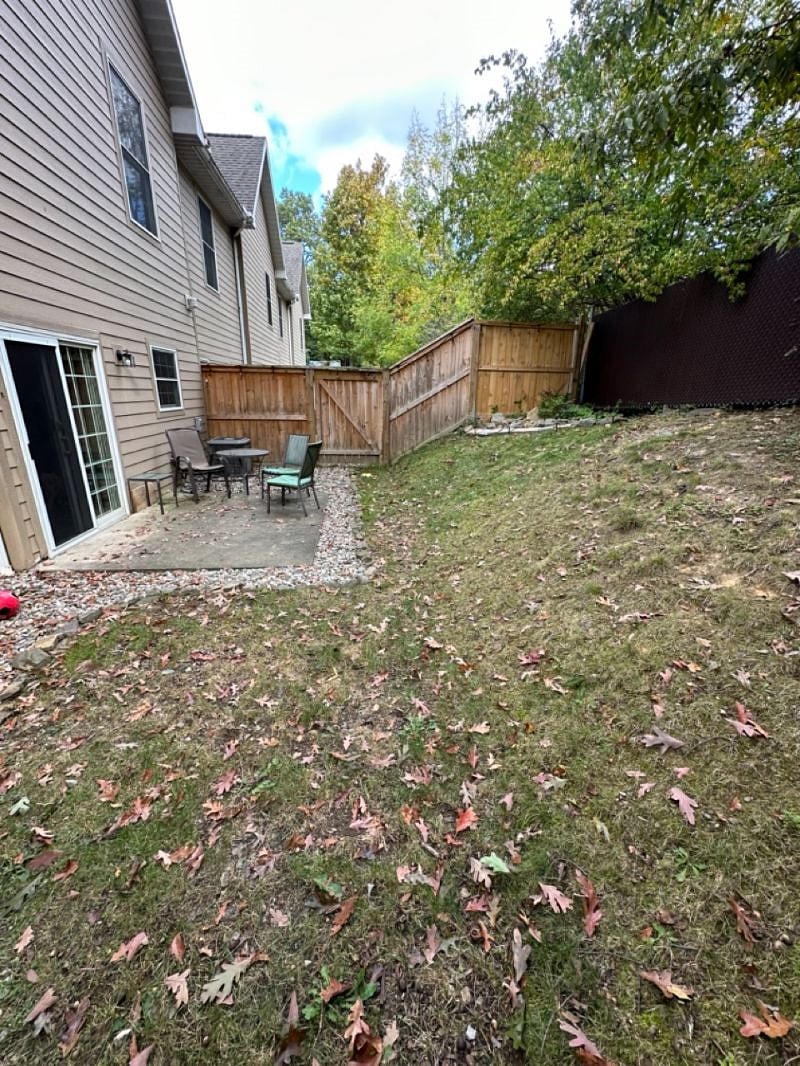 Spacious private backyard with sliding screen door, patio with outdoor furniture. 