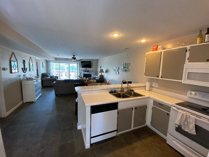 Entry door. Kitchen, living room, sliding door to lakefront deck.