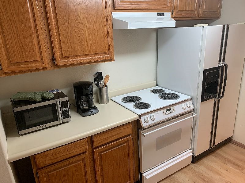 Kitchen with full size stove / oven and refrigerator.