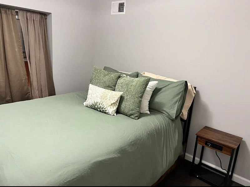 Secondary bedroom with end tables that have built-in chargers and a full bathroom next door.