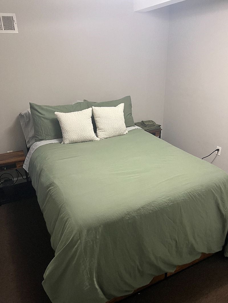 Secondary bedroom with end tables that have built-in chargers.