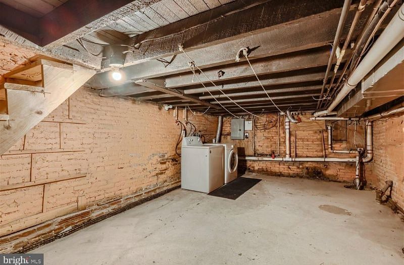Unfinished basement with a washer and dryer, plus lots of room for storage. 