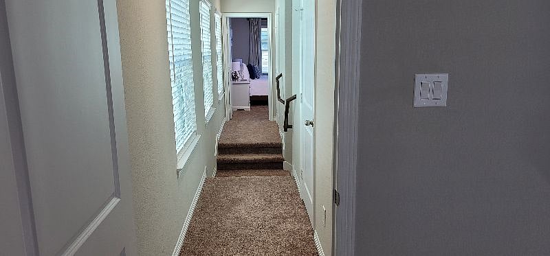 View from primary bedroom down the hallway leading to the secondary upstairs bedroom.