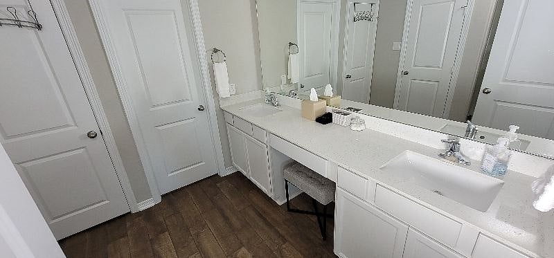Door to closet in primary bathroom with luggage rack and roll away bed.