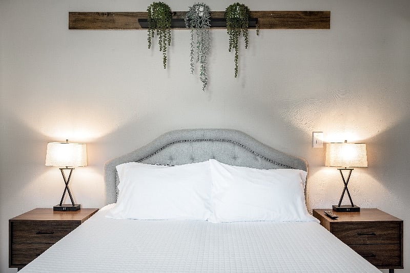 Primary bedroom suite with bathroom ensuite off kitchen. These touch lamps have USB charging capability, and all bedrooms have easy-access power strips for your electronics.