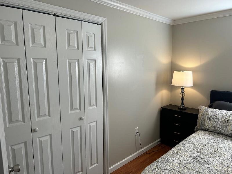 Bedroom with a queen sized bed, hardwood floor, large closet and chest of drawers. This room also has a smart television and a ceiling fan.