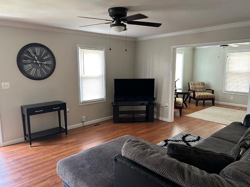 Living room with very comfortable sofa and large smart Television. Hardwood floors throughout the home.