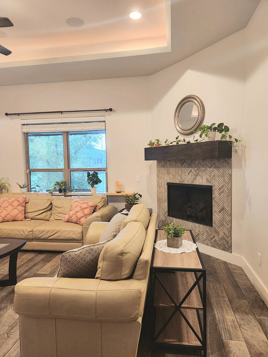Living room with built-in speakers and surround sound system, fireplace and mirror.