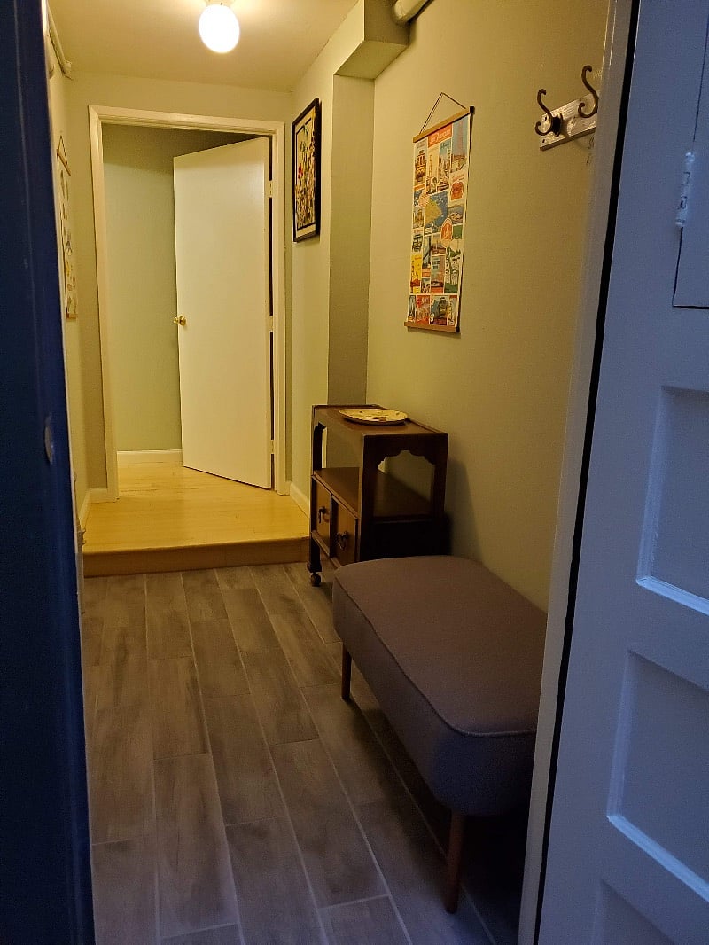 entryway to the suite has a place to store shoes, keys, umbrellas and jackets