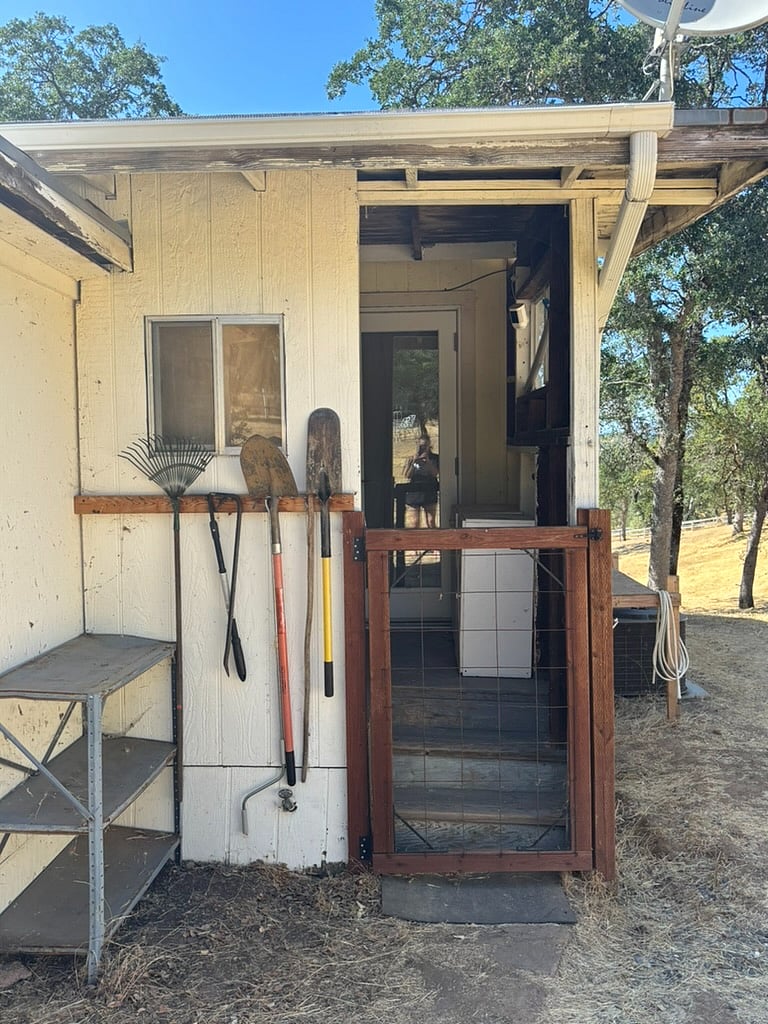 The covered porch which houses the laundry center for both units and the private entryway for the in-law unit