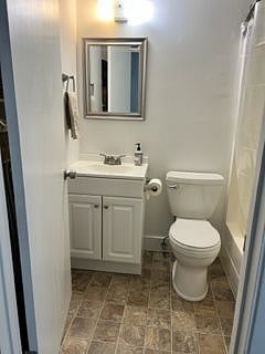 New vanity and toilet with tub-shower. Built in shelves behind bathroom door.