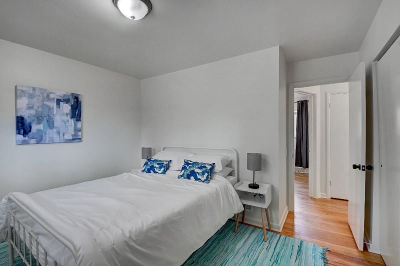Queen bed with comfy mattress, comforter, nightstands with charging lamps, and dresser in the closet. Blackout curtains.