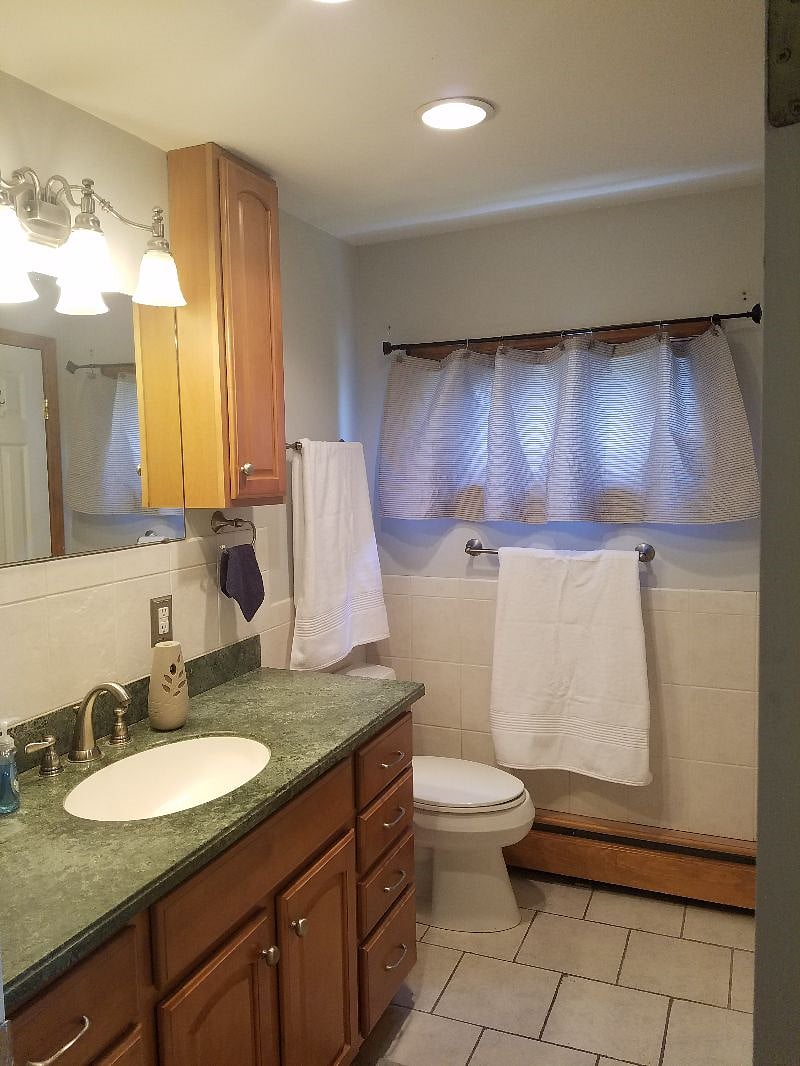 Full guest bath with combination tub/shower and linen closet.