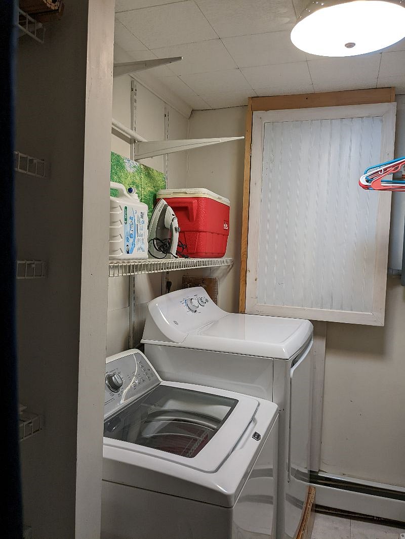 Separate laundry room with HE washer and dryer. Area to hang clothes or storage.