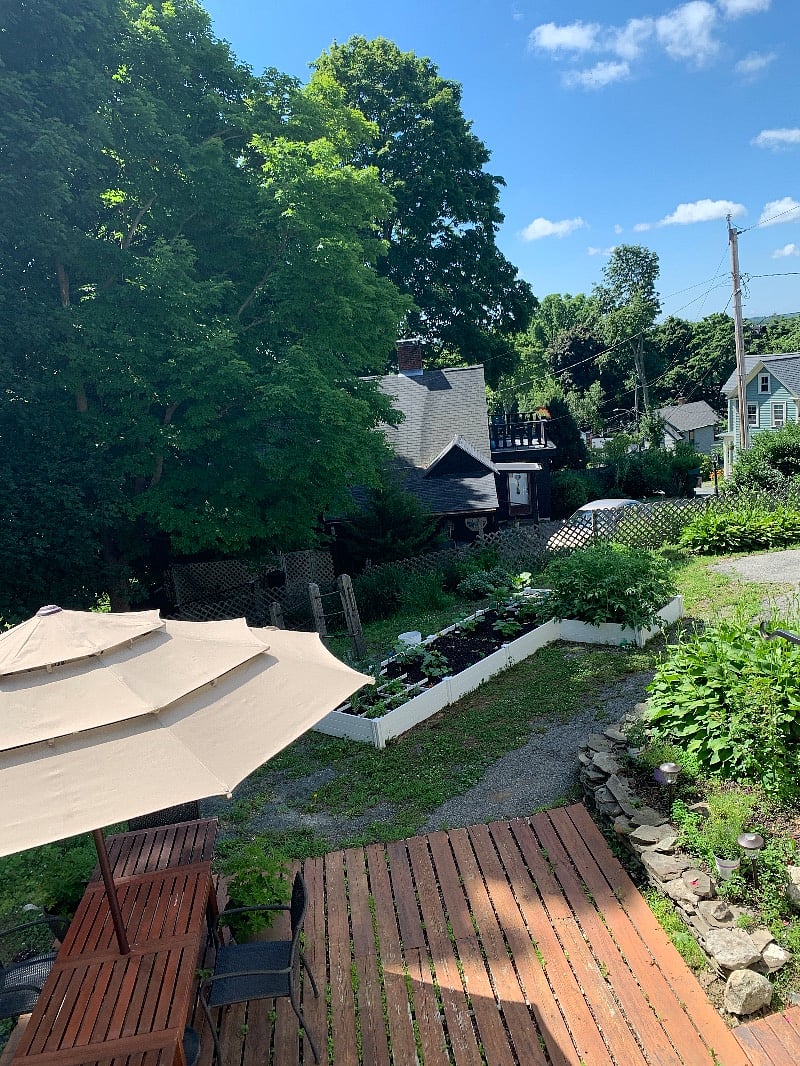 View from top of rear steps overlooking patio, garden, and houses below.