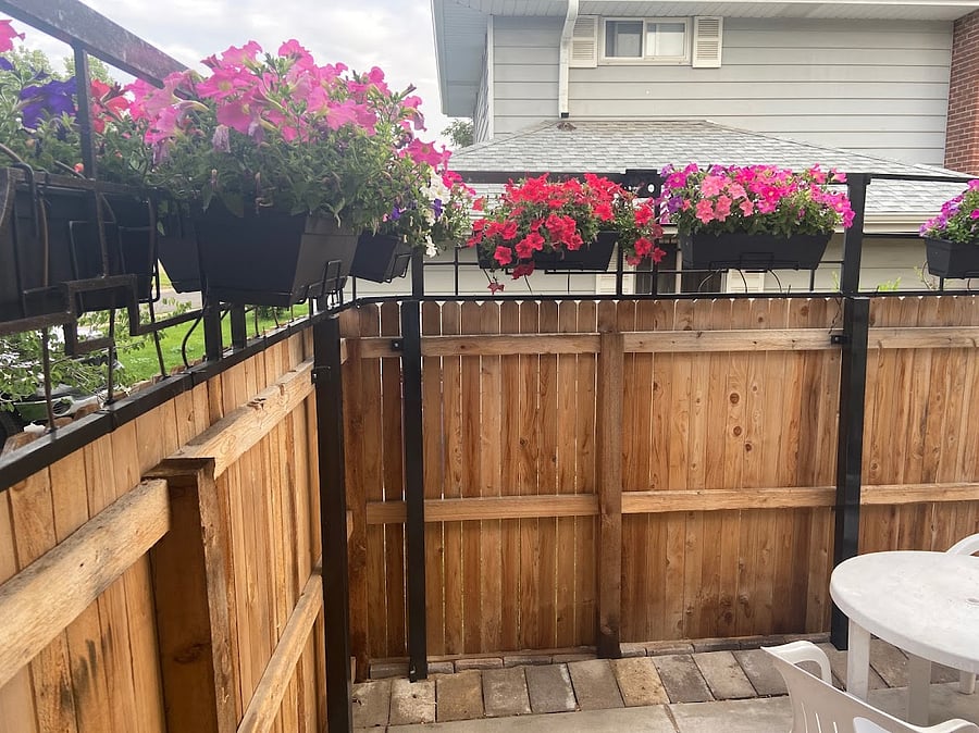 Just through the gate is the private patio, 10 x 15, for the unit.  Summer flowers are lovely.  The patio has a table with four chairs, and an iron bench that seats two.