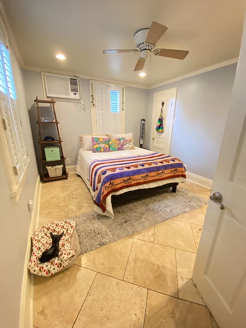 Bedroom with Ceiling Fan, Shelves with storage tubs, and Queen size bed.