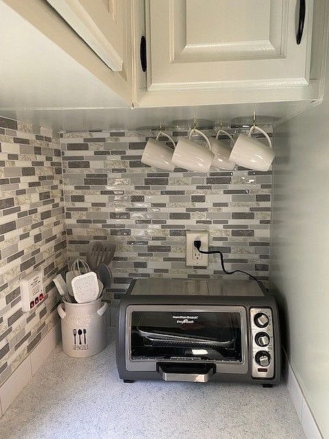 side view of counter space.   Blender, coffee pot, microwave, oven and stove top as well
