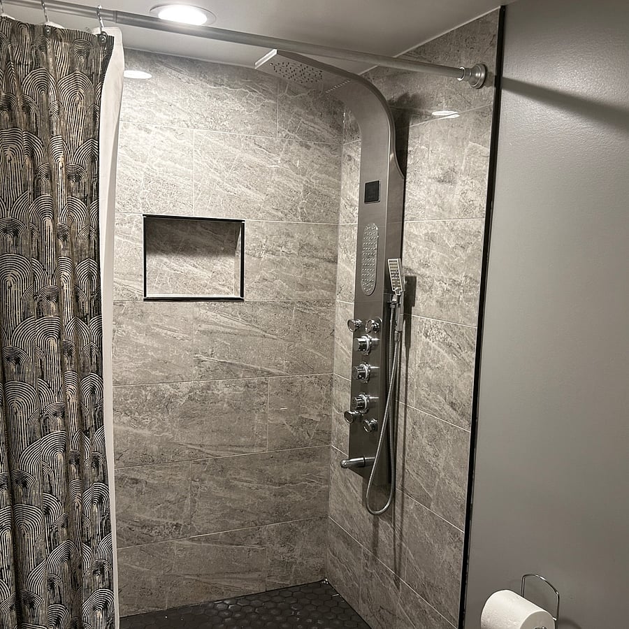 Shower in private bathroom with body spray & handheld shower head combo.