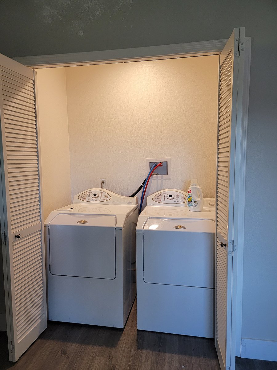 Full washer/dryer with laundry basket and drying rack.