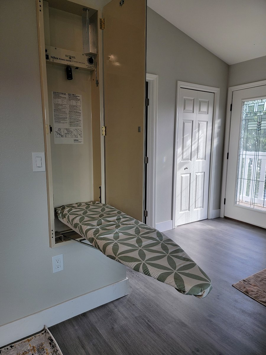 In wall, hard wired ironing board with full length mirror.
