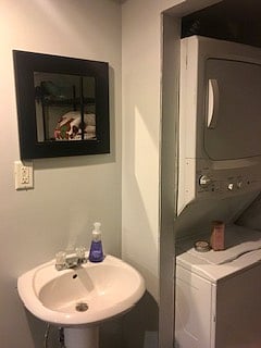 Bathroom with shower and stacked washer/dryer.