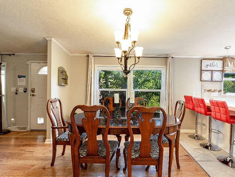 Enjoy a roomy dining table that seats 6 people. There is an extension if needed. The views of the Asheville North Carolina mountains and spring flowers are right outside the window. 3 can be seated at the bar with adjustable modern stools.