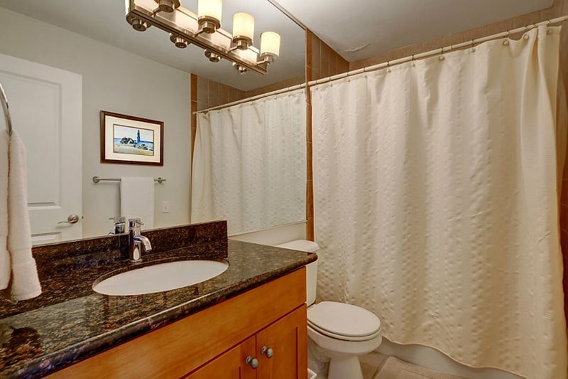 Updated bathroom graced with granite and cherry wood