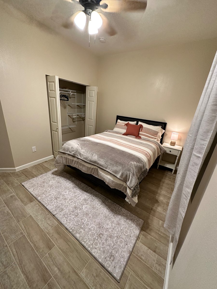 Larger bedroom with a queen size bed.