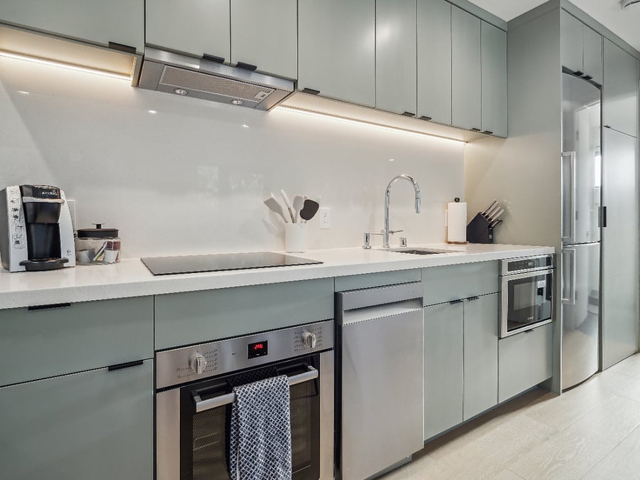 Fully equipped kitchen with cooktop, oven, dishwasher, garbage disposal, microwave, refrigerator.