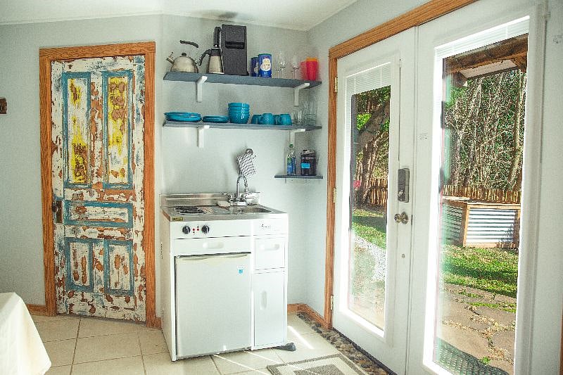 Downstairs living room area with kitchenette and doors to backyard.