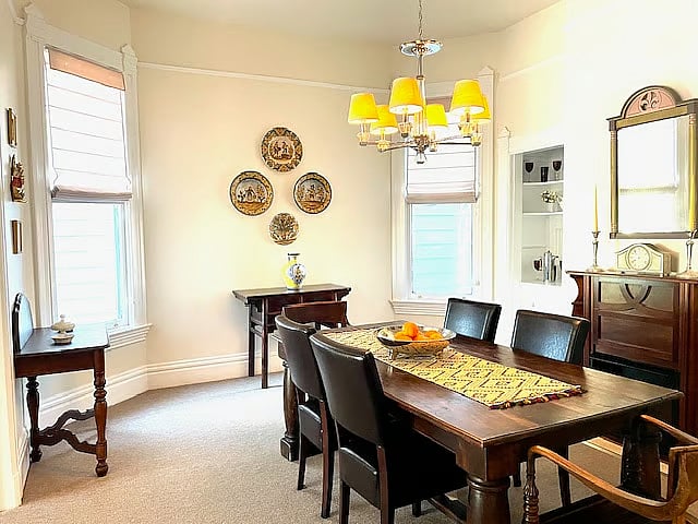 Formal Victorian dining with a decorative fireplace. A perfect place for entertaining and coworking.