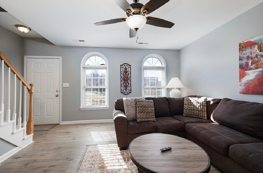 Large and bright living room with comfortable furnishings, including a flatscreen TV.
