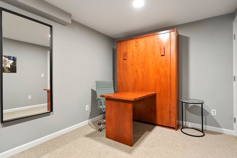 Studio with Wall bed closed and attached desk open making a second workstation. Desk closes allowing for space to do exercise or other activities.