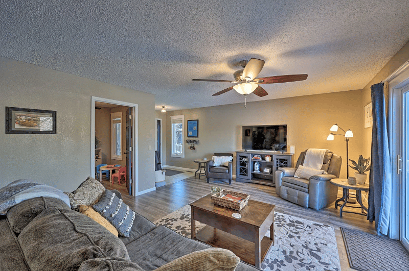 Living room with reclining couch, smart TV, deck access, view of golf course
