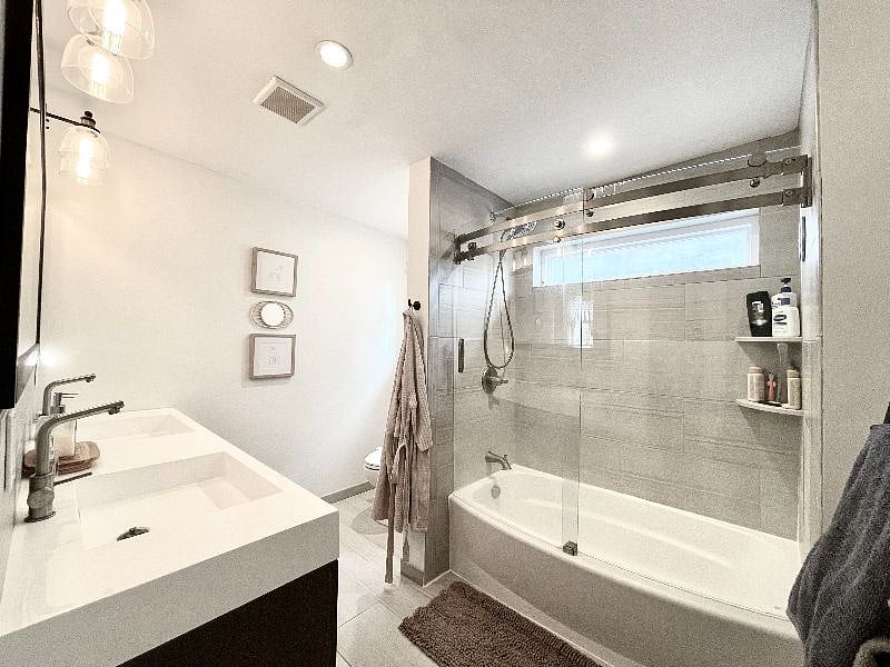 Bathroom with large shower, double vanity, and toilet