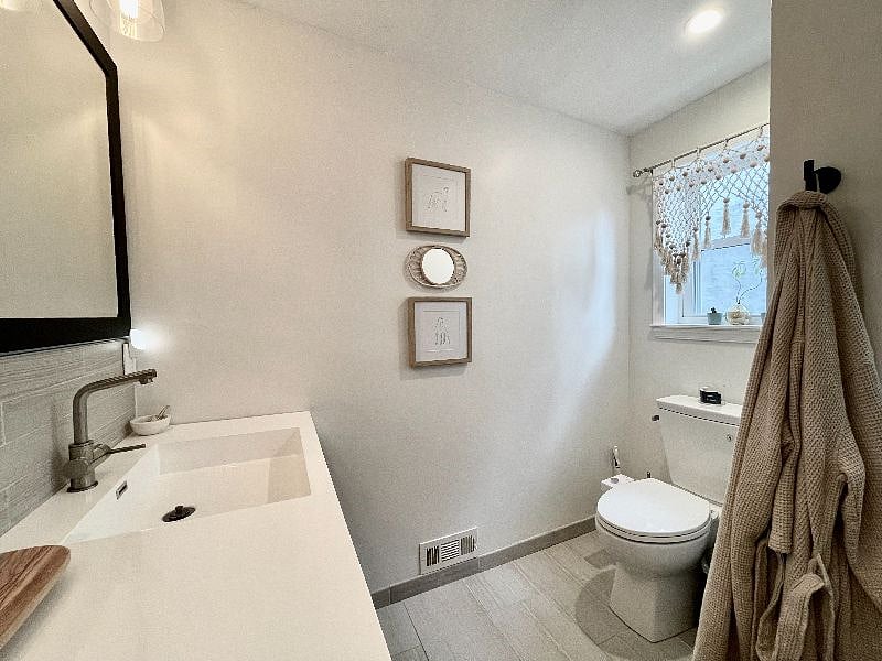 Bathroom with large shower, double vanity, and toilet