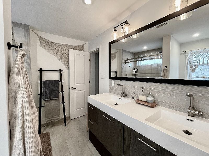 Bathroom with large shower, double vanity, and toilet