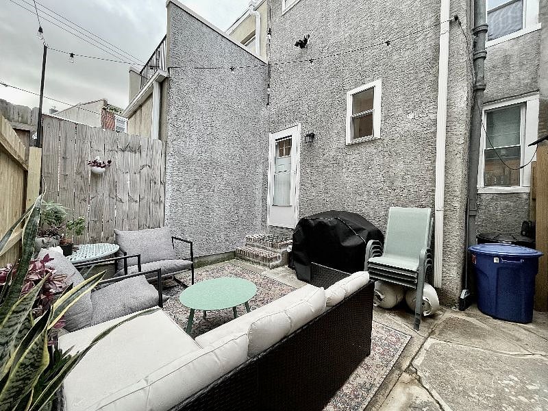 Private back patio with propane gas grill, outdoor patio furniture, and bistro lights