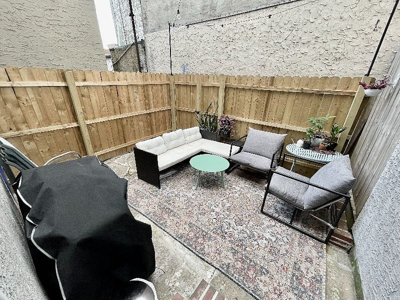 Private back patio with propane gas grill, outdoor patio furniture, and bistro lights