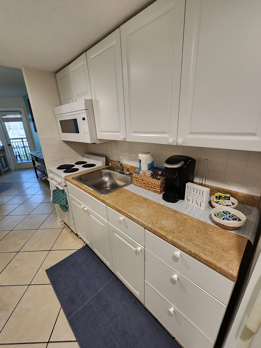 Kitchen with stove, microwave, sink, full sized refrigerator.. stocked with kitchen essentials & Keurig coffee pot & coffee n creamer provided for your first morning!  