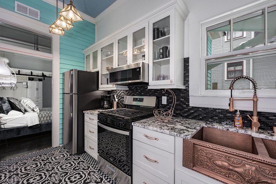 High end galley kitchen w/ copper fixtures and granite countertops, gas stove/oven