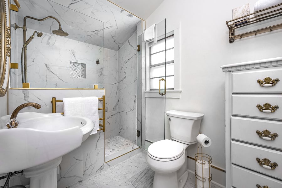 Marble bathroom with walk-in shower, rain can shower head, swinging glass door (nearly 180 swing: 90 inward and outward), antique brass fixtures