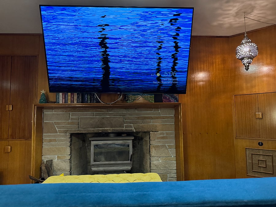 The den is a comfortable place to watch TV, read a book, play a game or do a puzzle.
Wood burning fireplace with extra large Ultra High Definition TV.