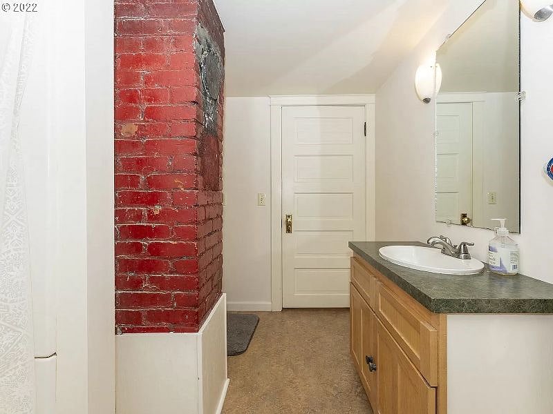 Bathroom w/ corner shower & enough space for a litter box.