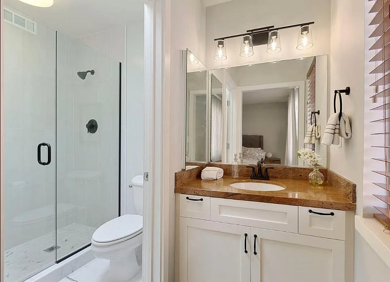 Sunny hotel-style master bathroom with a skylight