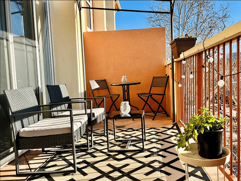 Expansive patio with a bistro set, lounge chairs, and a BBQ grill