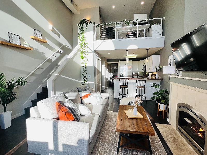 Sunlit living/dining room with a cozy fireplace and a 55" TV