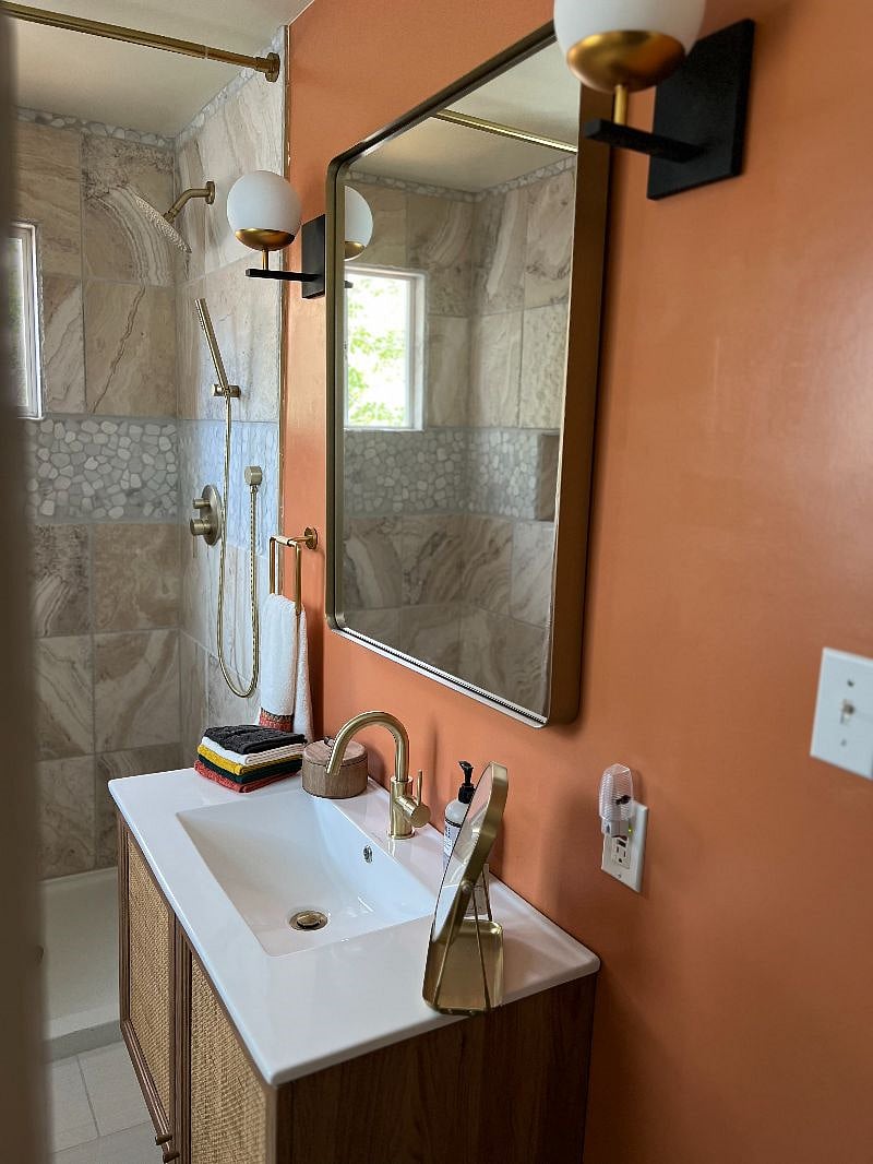 Tiled shower with window allow lots of natural light into the bathroom.