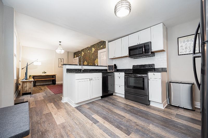 Newly renovated kitchen with granite countertops, stainless steel appliances, and white cabinets.